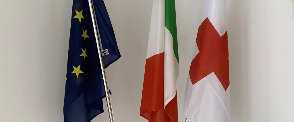 Disposizione delle bandiere: l'Italia in prima posizione, l'Europa in seconda posizione e la Croce Rossa in terza posizione